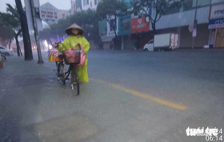 Residents navigated flooded streets to earn a living early on the morning of November 5, 2024 in Da Nang City, central Vietnam. Photo: Hong Giang