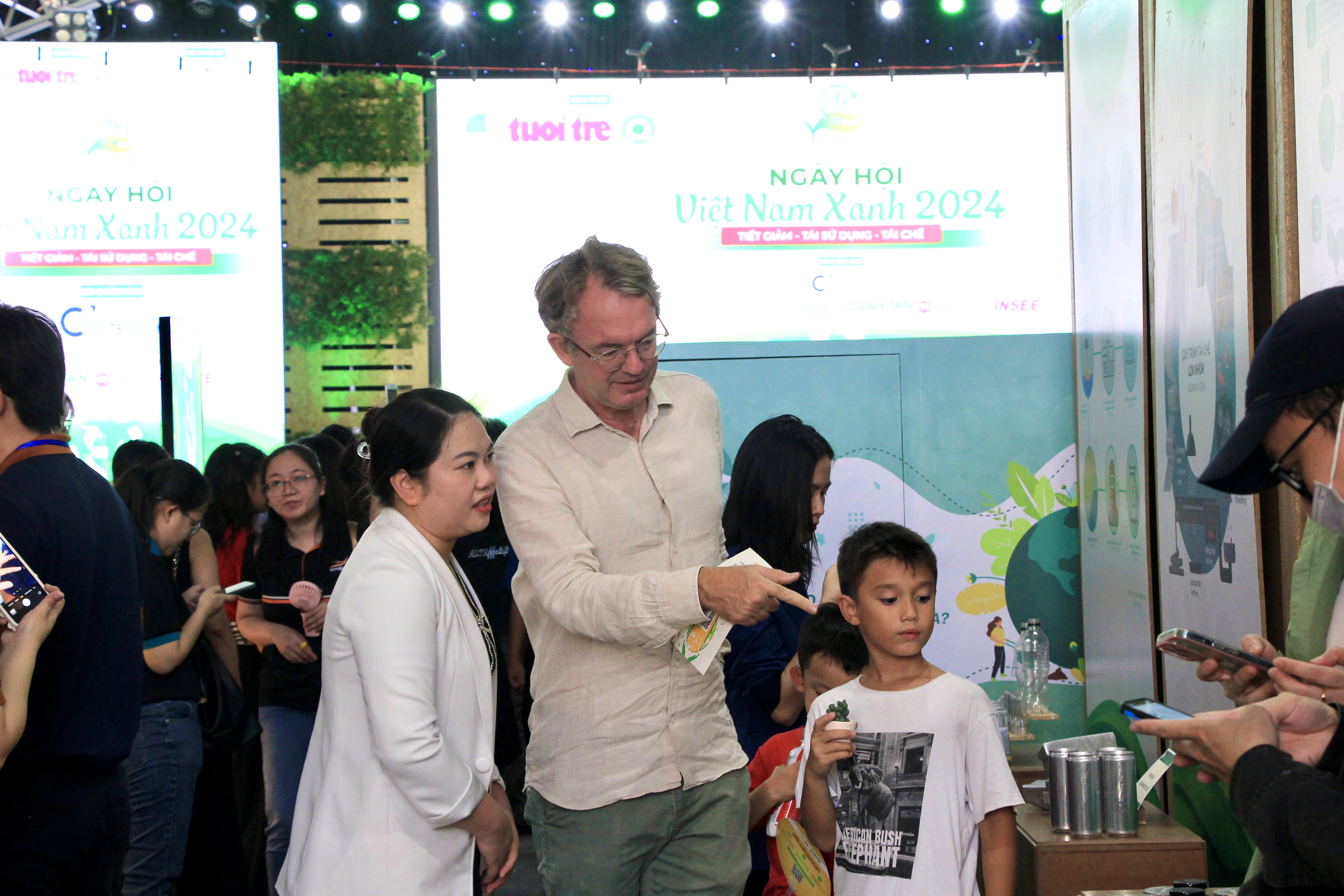 Harold de Walque and his children visit a booth at the Green Vietnam Festival in Ho Chi Minh City on November 9, 2024. Photo: Dong Nguyen / Tuoi Tre News