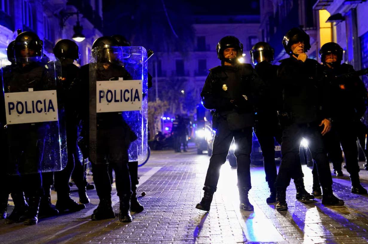 Police officers stand guard as people protest against the management of the emergency response to the deadly floods in eastern Spain, in Valencia, Spain, November 9, 2024. Photo: Reuters