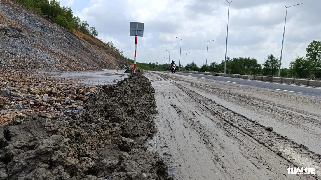 Construction crews have been instructed to clear mud that has flowed onto the road in Da Nang, central Vietnam. Photo: Doan Cuong / Tuoi Tre