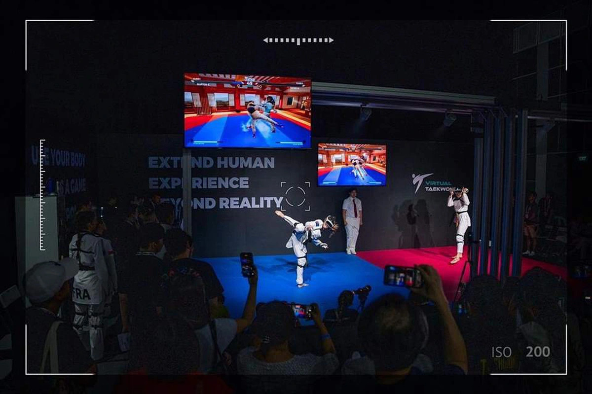 Two athletes compete in virtual reality, with the match displayed on a large screen for the audience. Photo: Supplied