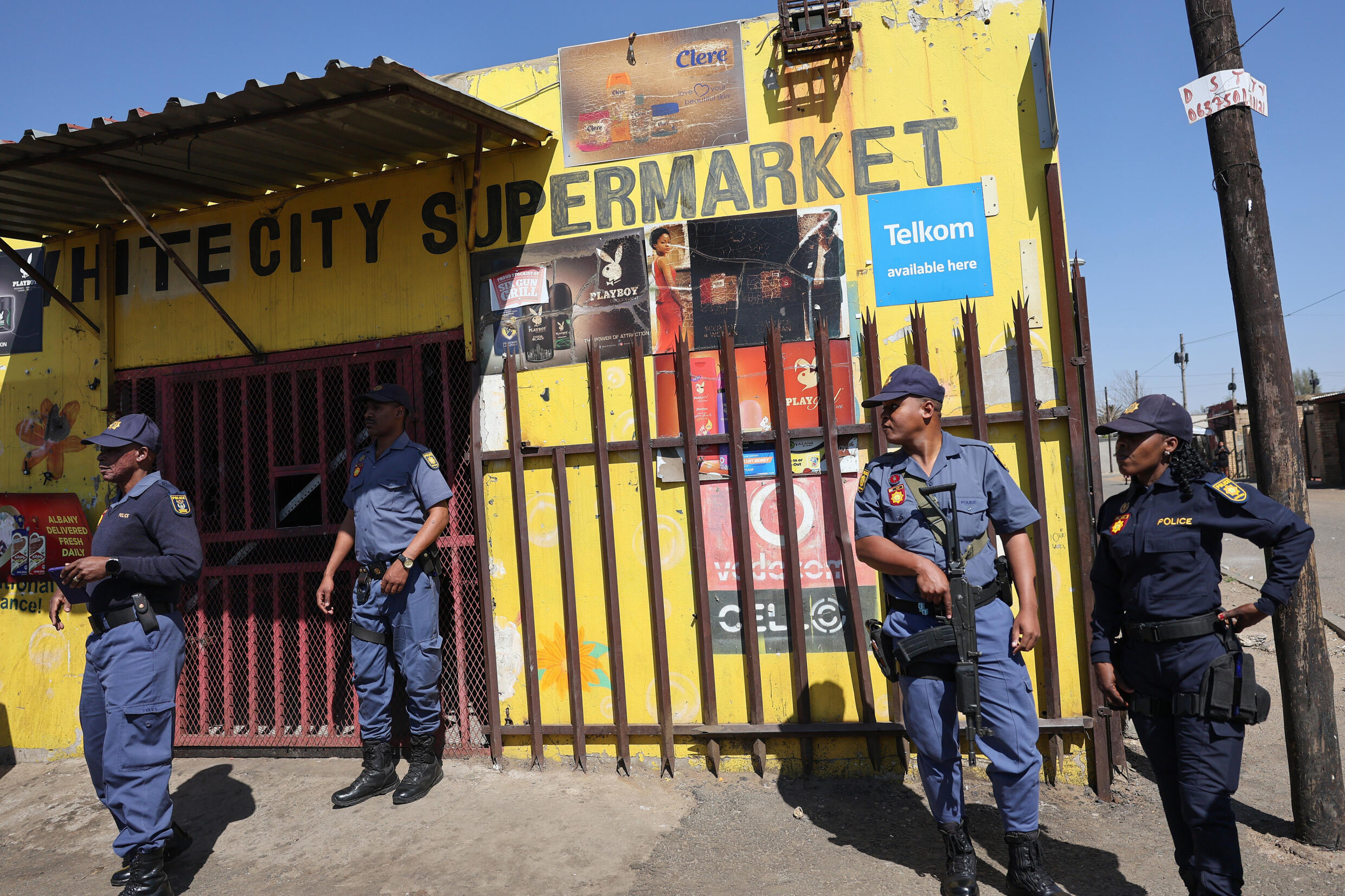 South African Police Service (SAPS) stand next to a shop that was shut down by members of Operation Dudula in White City, Soweto, on August 17, 2024. Photo: AFP