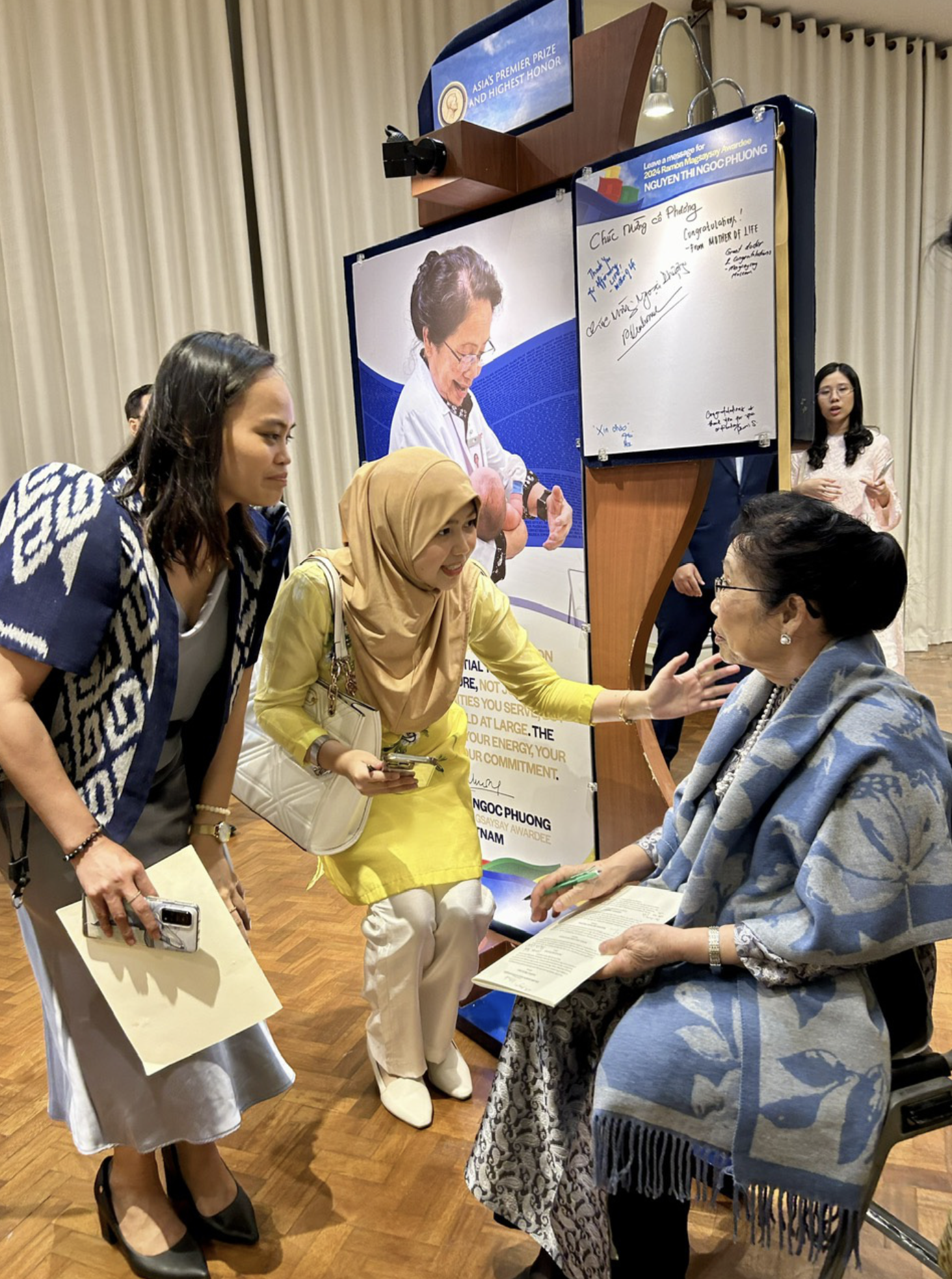 Two Philippine students ask for Prof. Phuong’s signature after the award ceremony. Photo: T.T.D. / Tuoi Tre