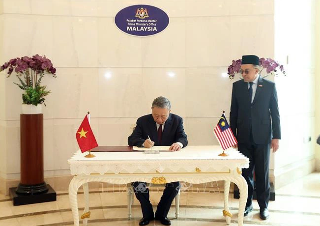 Vietnamese Party chief To Lam writes in a guest book. Photo: Vietnam News Agency