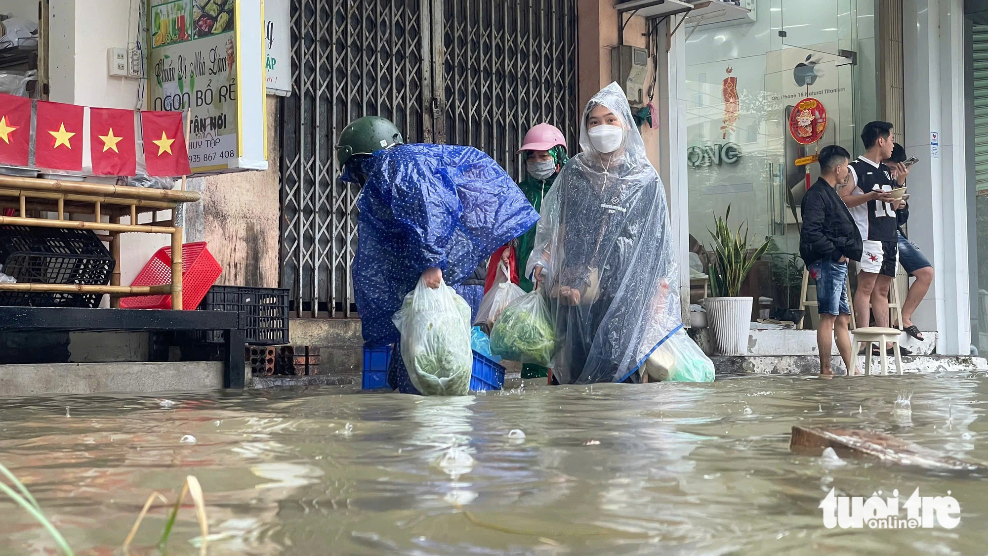 Pedestrians wade through the flooded Ha Huy Tap Street to buy food in Hue City, Thua Thien-Hue Province, central Vietnam, November 25, 2024. Photo: Cong Ngo / Tuoi Tre