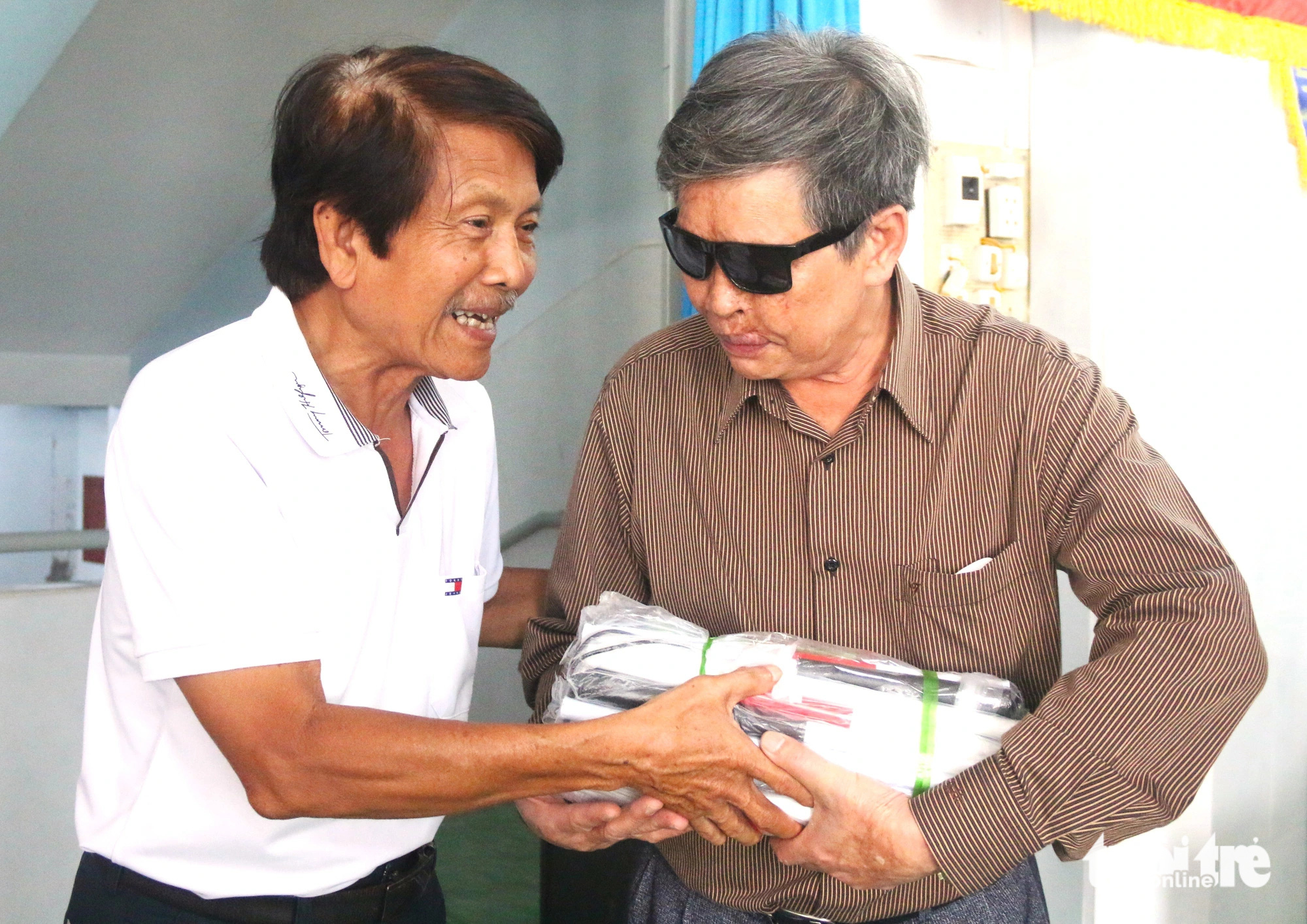 Hang Chuc Nguyen (L), a representative of the Hang and Han families in Khanh Hoa Province presents walking sticks to a blind learner, November 25, 2024. Photo: Nguyen Hoang / Tuoi Tre