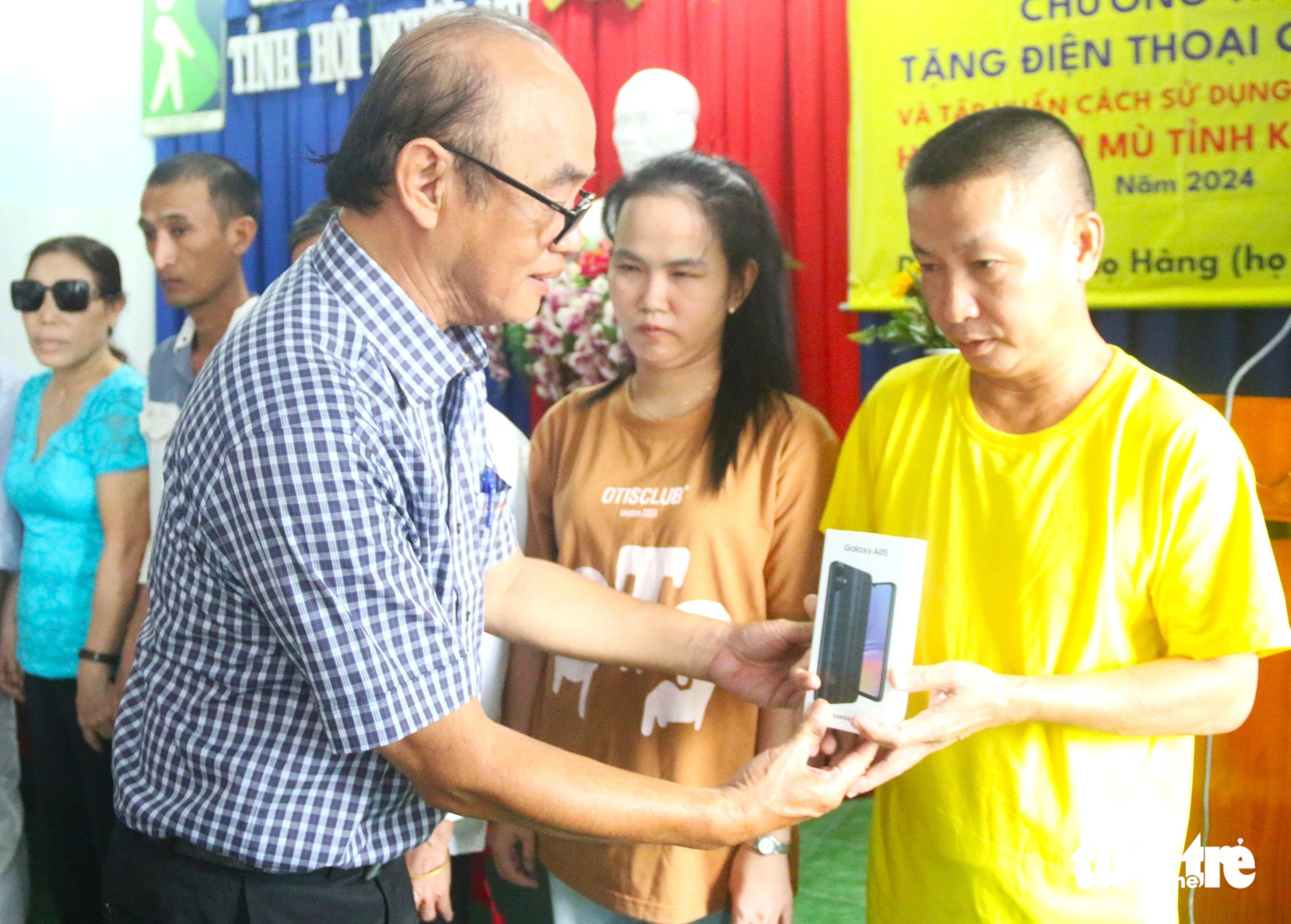 Nguyen Thanh Tam, director of the Ho Chi Minh City Audio Books Charity Fund for the Blind, presents smartphones to blind individuals in Khanh Hoa Province November 25, 2024. Photo: Nguyen Hoang / Tuoi Tre