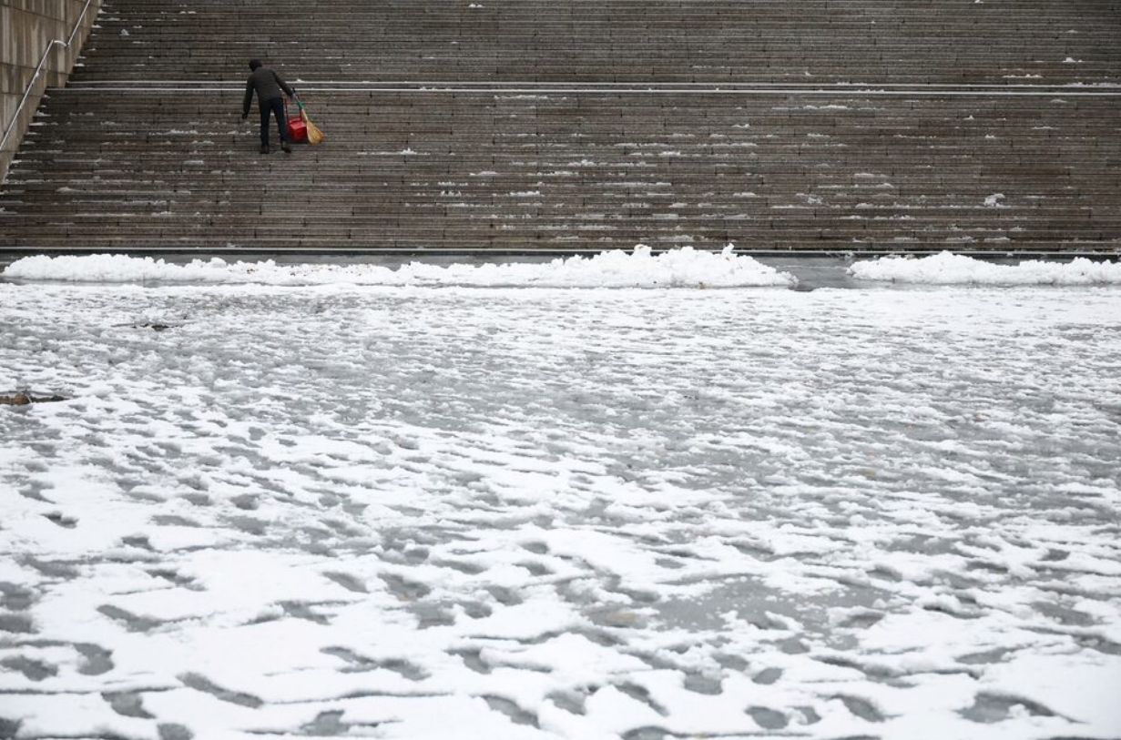 A man works during heavy snow fall in central Seoul, South Korea, November 27, 2024. Photo: Reuters