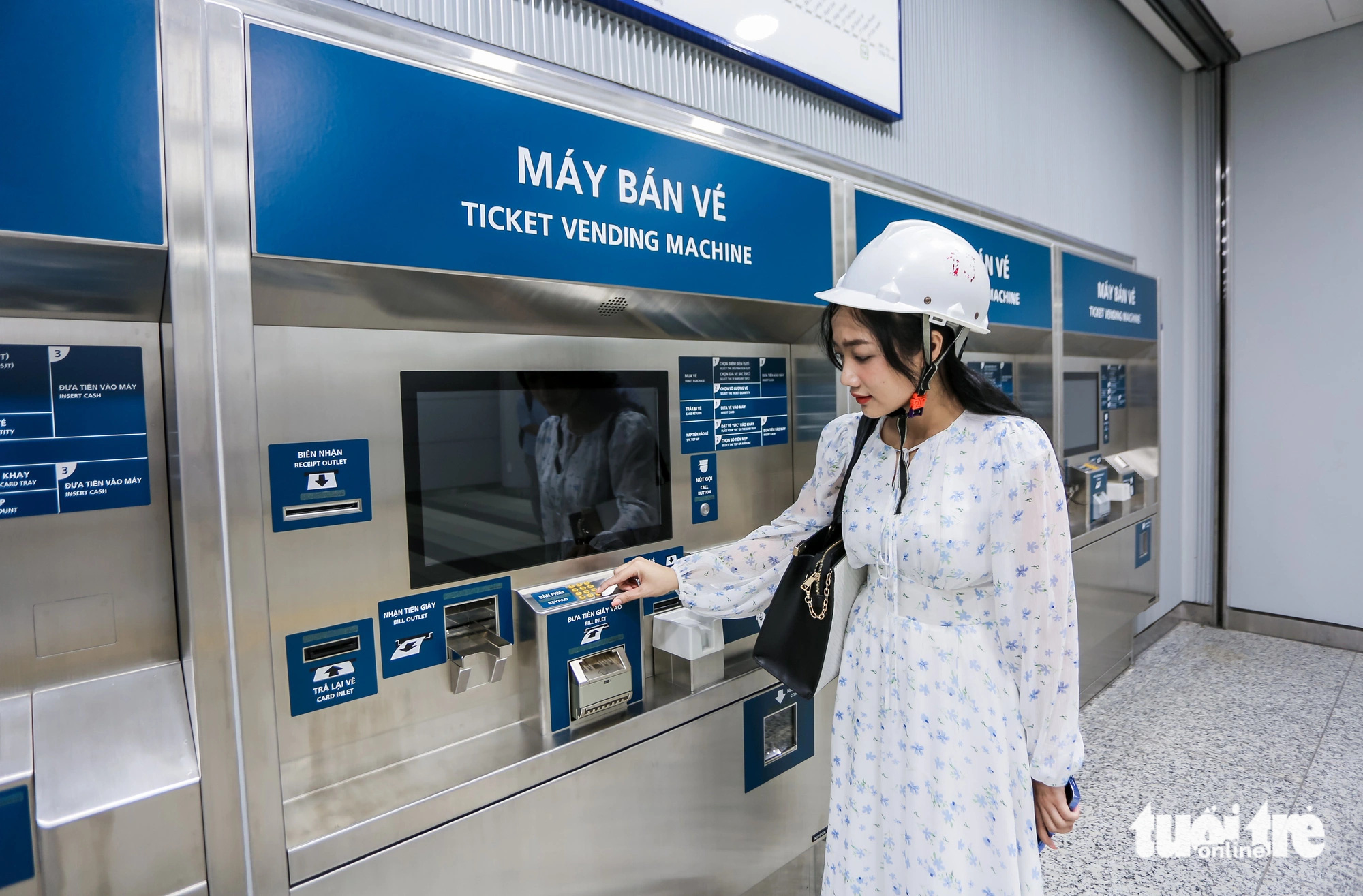 A reporter watches a ticket vending machine at Ben Thanh underground station on metro line No. 1 in District 1, Ho Chi Minh City. Photo: Chau Tuan / Tuoi Tre