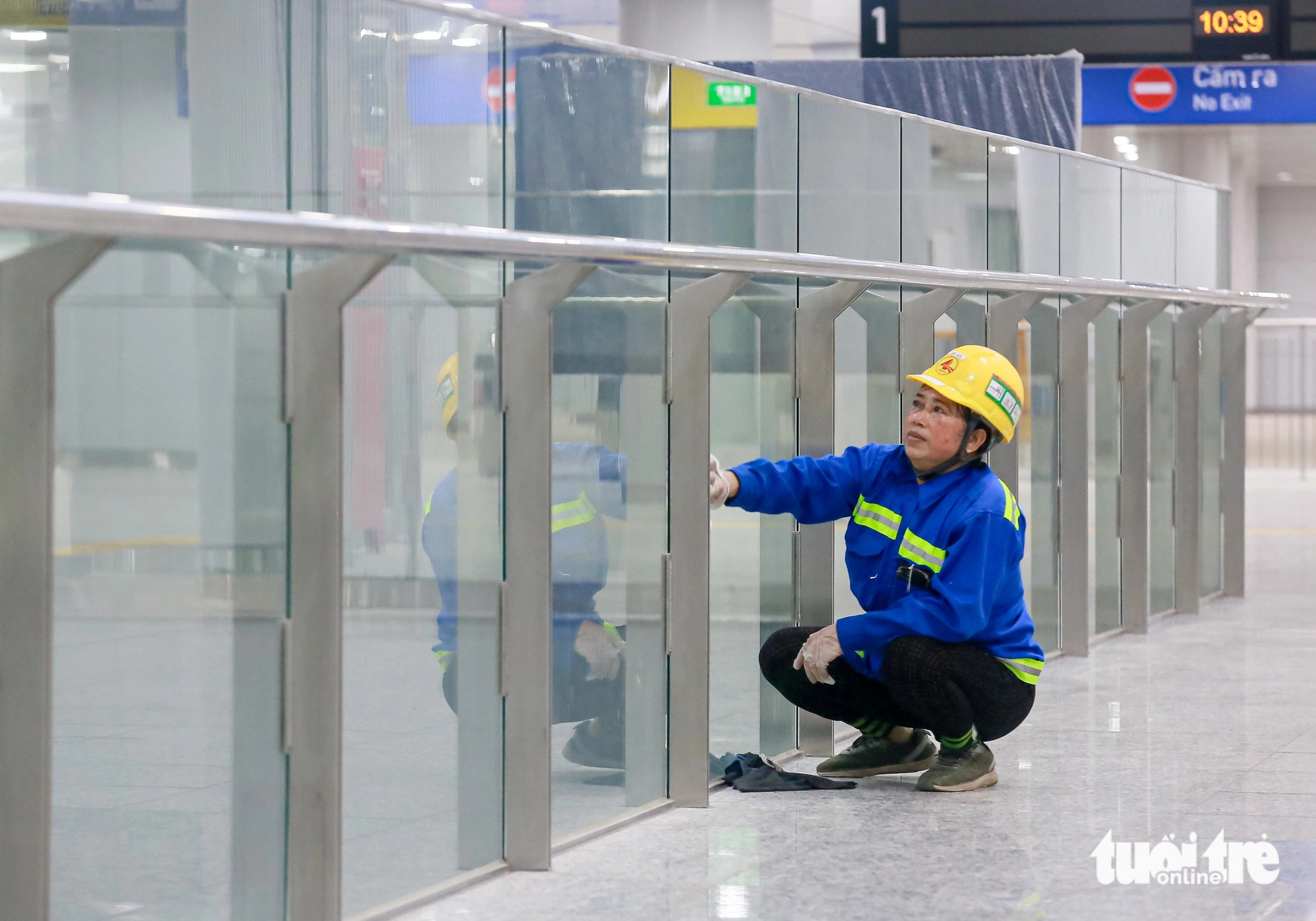 A worker cleans a glass railing at Ben Thanh underground station on metro line No. 1 in District 1, Ho Chi Minh City. Photo: Thu Dung / Tuoi Tre