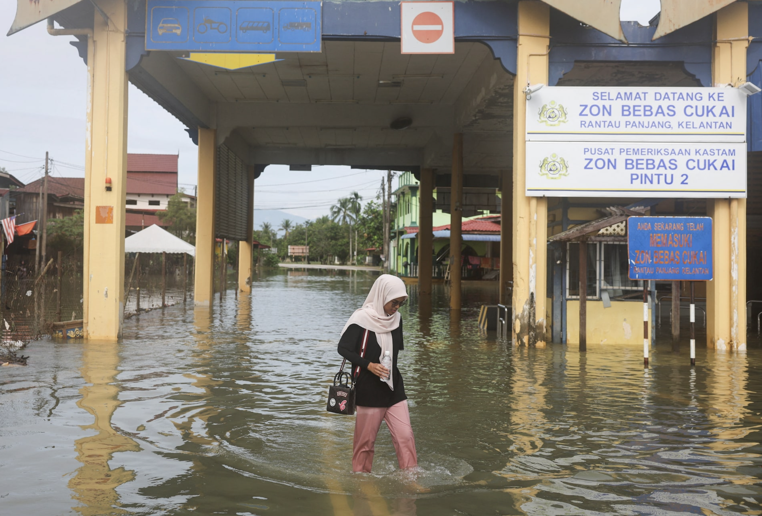 A woman wades through floodwaters in Rantau Panjang, Malaysia December 3, 2024. Photo: Reuters