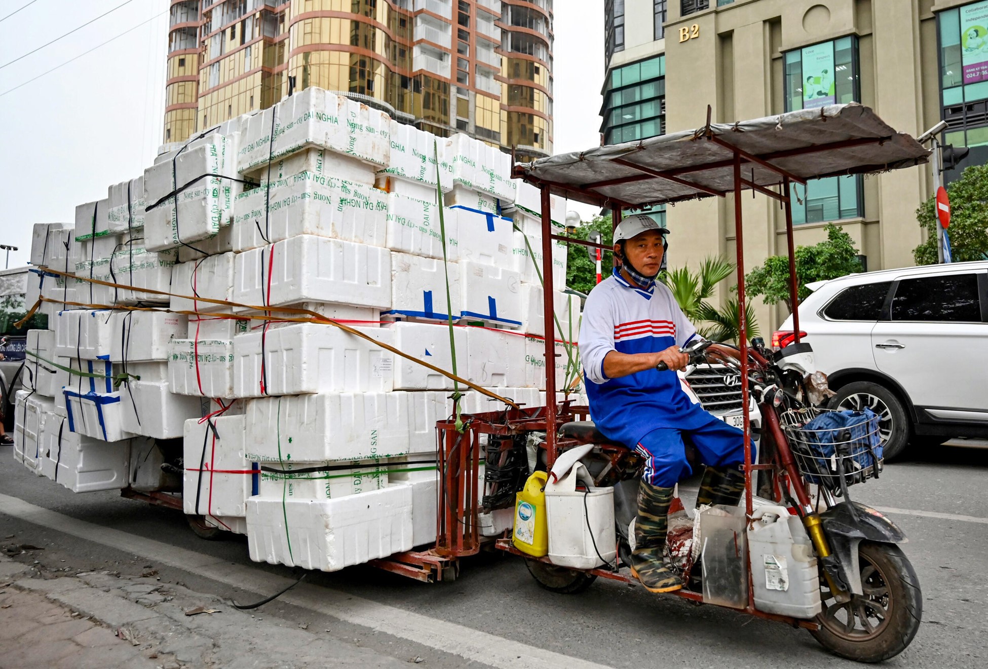 A man rides an electric motorbike carrying foam sheets on a street in Hanoi. Photo: AFP