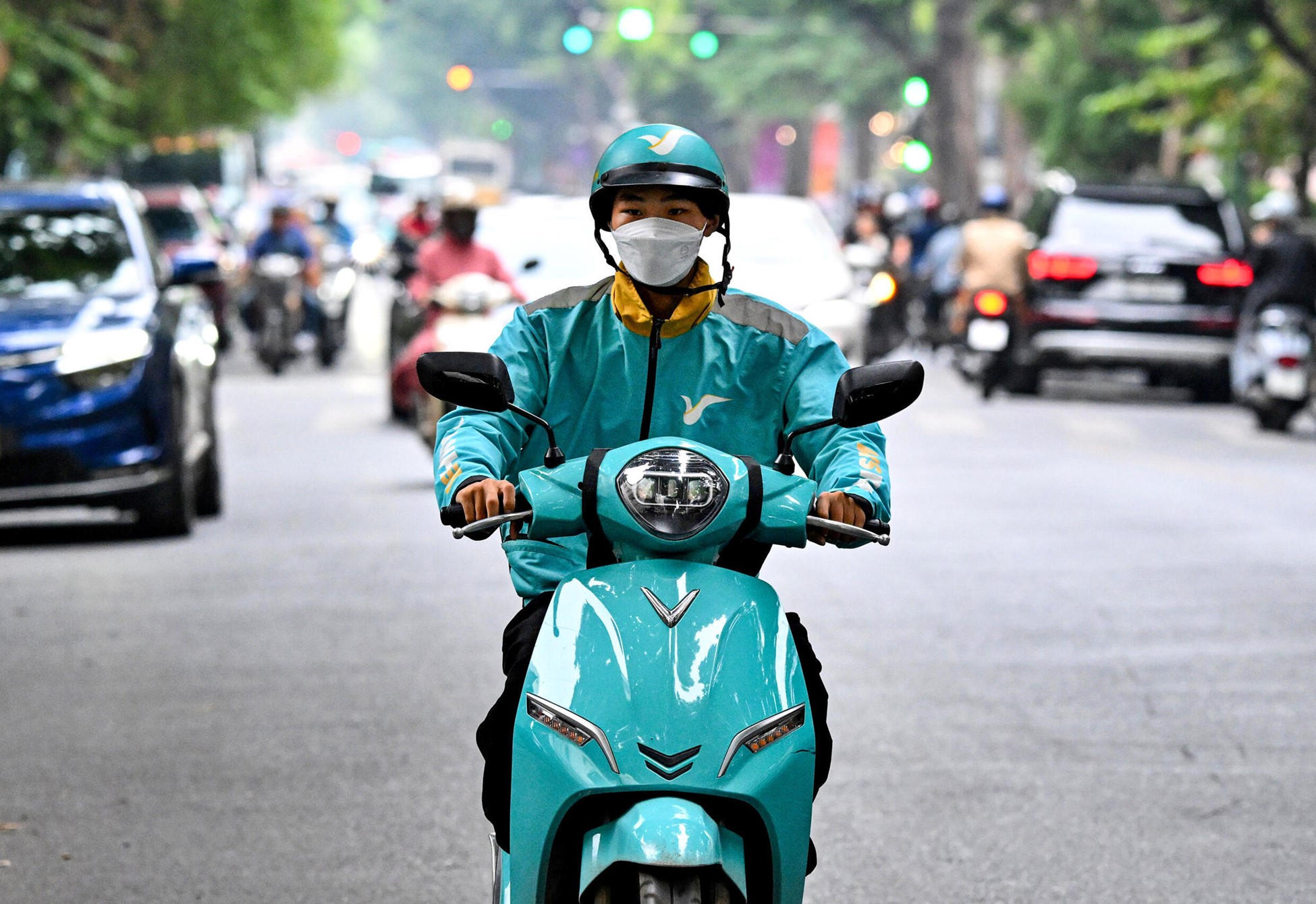 Motorbike taxi driver Phung Khac Trung rides his electric motorbike on a street in Hanoi. Photo: AFP