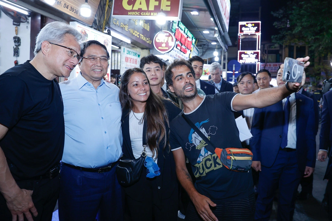 Prime Minister Pham Minh Chinh (L, 2nd) and Jensen Huang (L), president and CEO of Nvidia, pose with tourists at the Old Quarter in Hanoi, December 5, 2024. Photo: Doan Bac