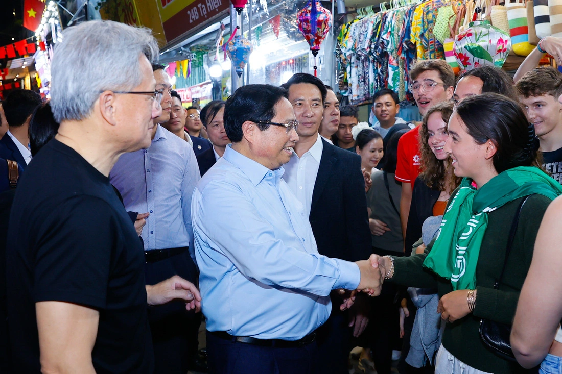 Prime Minister Pham Minh Chinh (in a blue shirt) shakes hands with international tourists at the Old Quarter in Hanoi, December 5, 2024. Photo: Doan Bac