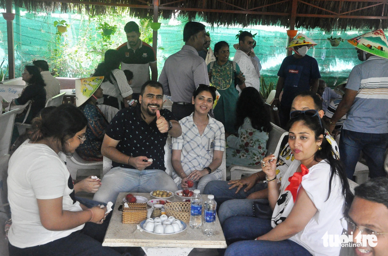 Indian tourists are treated to fruits and tea made with honey in the Mekong Delta region. Photo: Hoai Thuong / Tuoi Tre