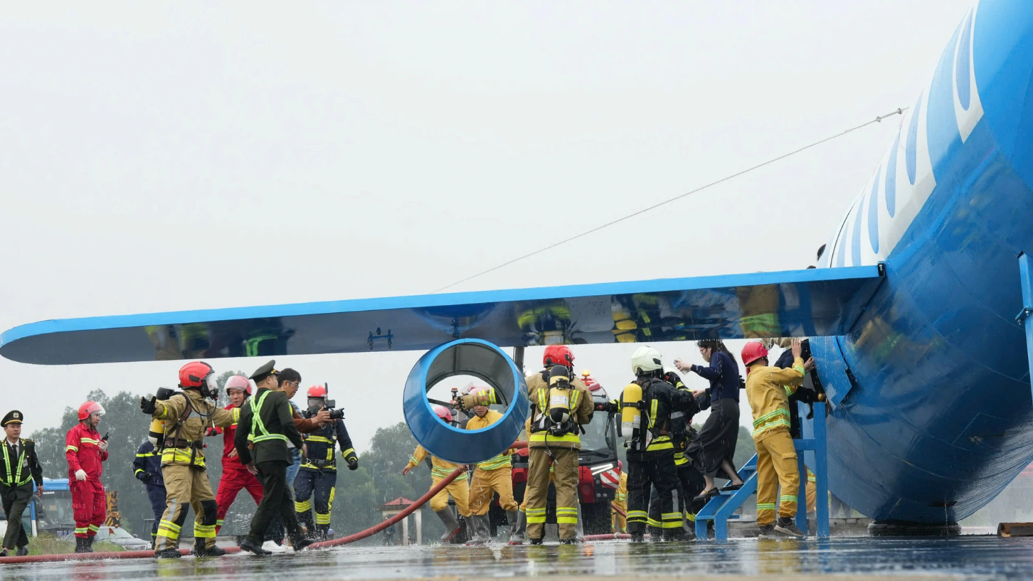 Rescuers evacuate passengers to safe shelters after a plane lands at Vinh International Airport and catches fire during a drill on December 12, 2024. Photo: NIA