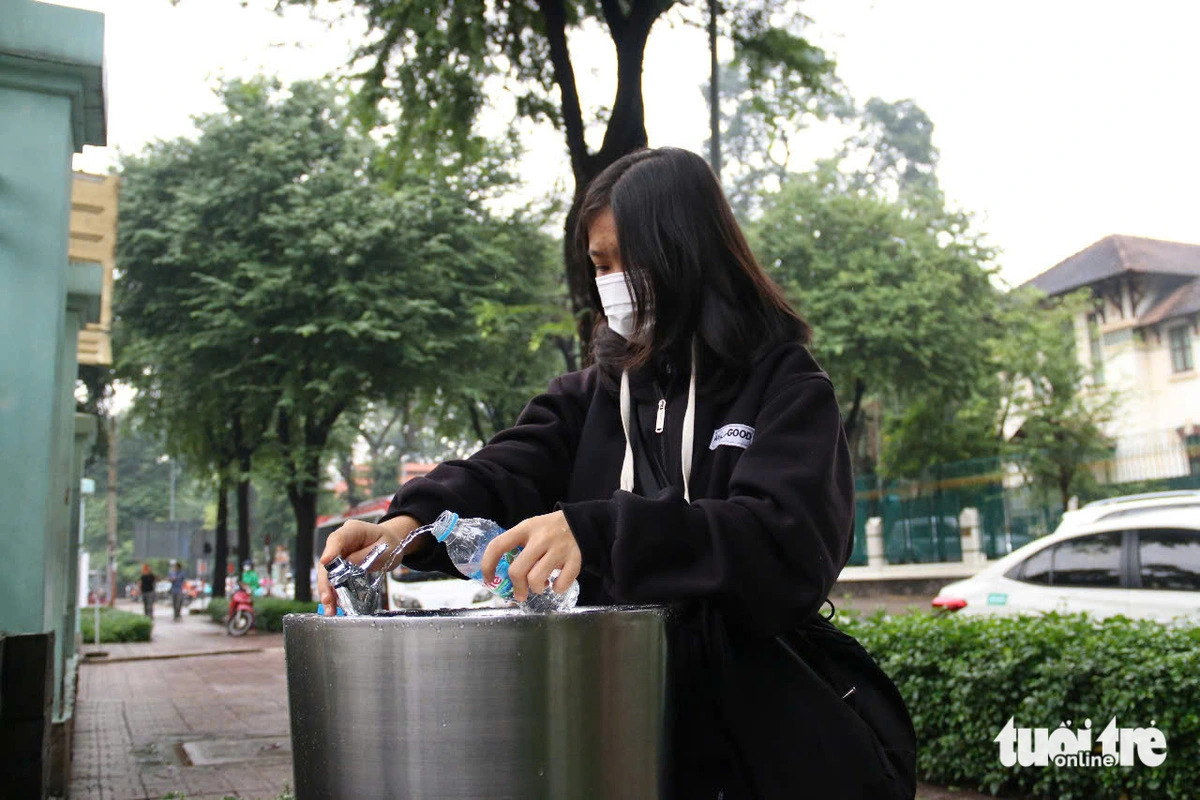 Nguyen Thuy Duong, a student at the University of Industry and Trade, fills up a bottle with tap water from a drinking water fountain installed in front of the War Remnants Museum in District 3, Ho Chi Minh City, southern Vietnam on December 14, 2024. Photo: Bui Nhi / Tuoi Tre