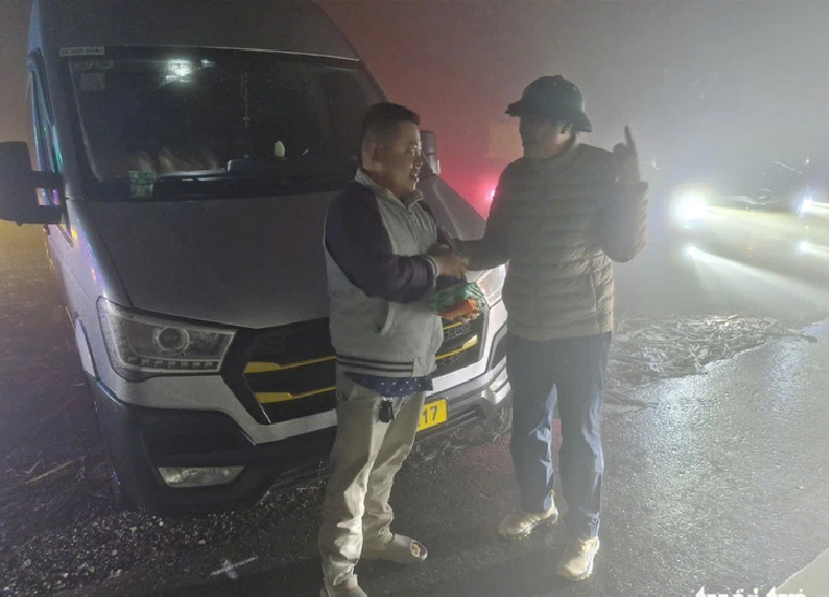 Dang Duc Hiep (R), secretary of the Party Committee in Da Lat City, Lam Dong Province, joins hands to provide food and drinks to the stranded people on Khanh Le Pass in Khanh Hoa Province. Photo: L.A. / Tuoi Tre