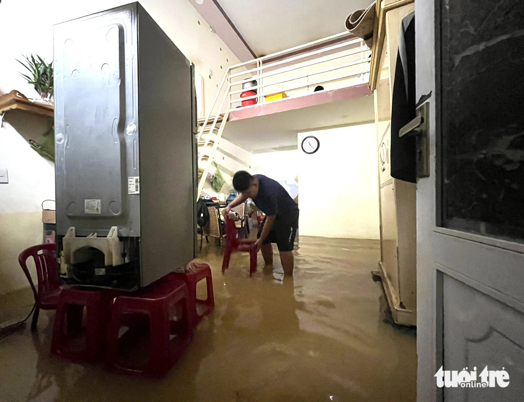 A resident in Vinh Thanh Commune, Nha Trang City, elevates household appliances to prevent damage due to flooding, December 15, 2024. Photo: Nguyen Hoang / Tuoi Tre