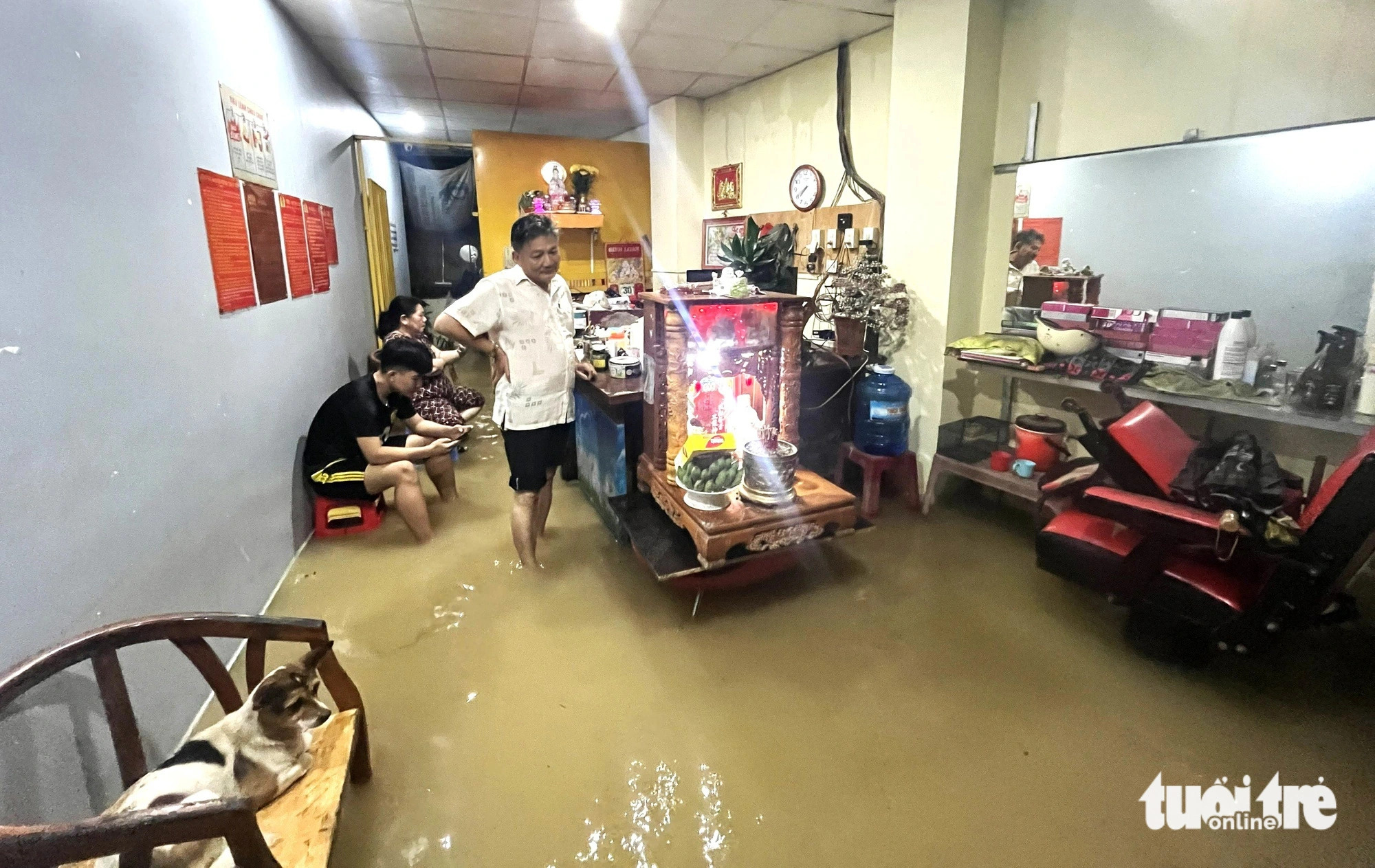 Owner of a hair salon in Vinh Thanh Commune, Nha Trang City, managed to move their belongings to higher ground, but the floodwaters kept rising, December 15, 2024. Photo: Nguyen Hoang / Tuoi Tre