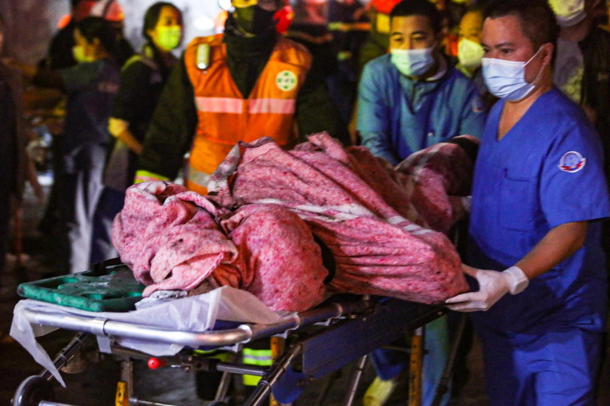 Rescuers remove a victim from a blaze at a coffee shop on Pham Van Dong Street, Bac Tu Liem District, Hanoi, December 18, 2024. Photo: Ngoc Nguyen / Tuoi Tre