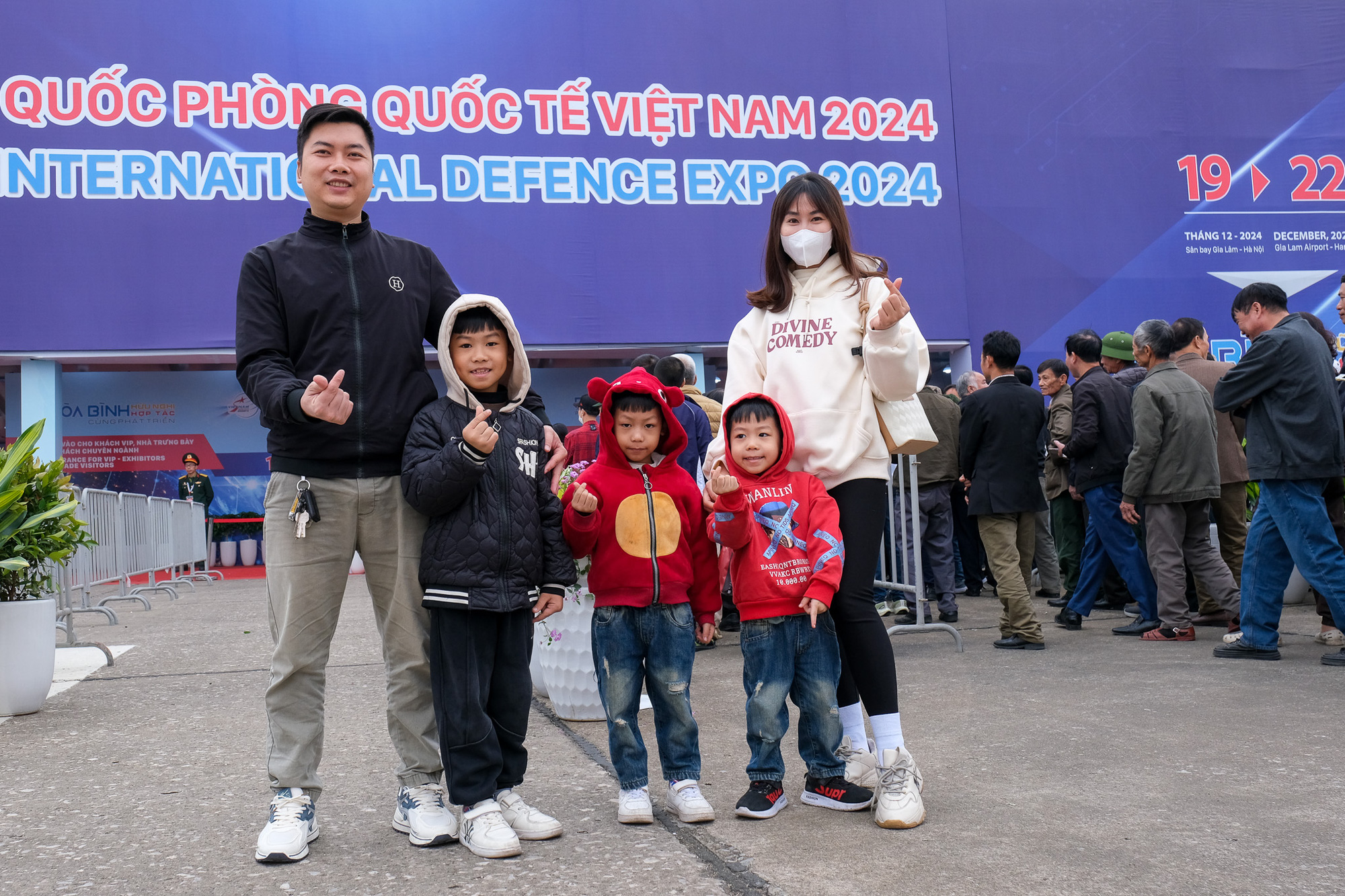 The family of Le Van Dong (L) and Hoang Thi Thien (R) poses at the Vietnam International Defense Expo 2024, held at Gia Lam Military Airport in Long Bien District, Hanoi, December 21, 2024. Photo: Ha Quan / Tuoi Tre