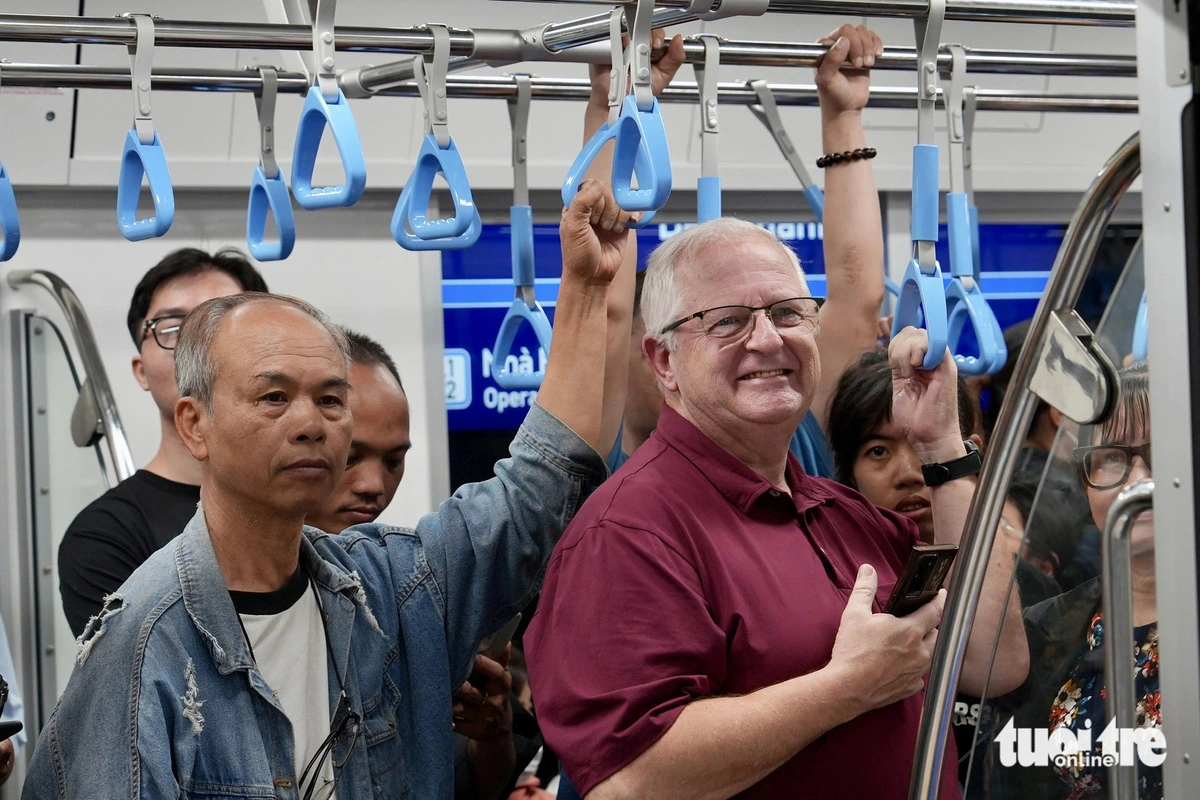 A foreign man (R) is seen among other passengers enjoying a trip on a train of Ho Chi Minh City’s metro line No. 1, which started official operations on December 22, 2024. Photo: Huu Hanh / Tuoi Tre