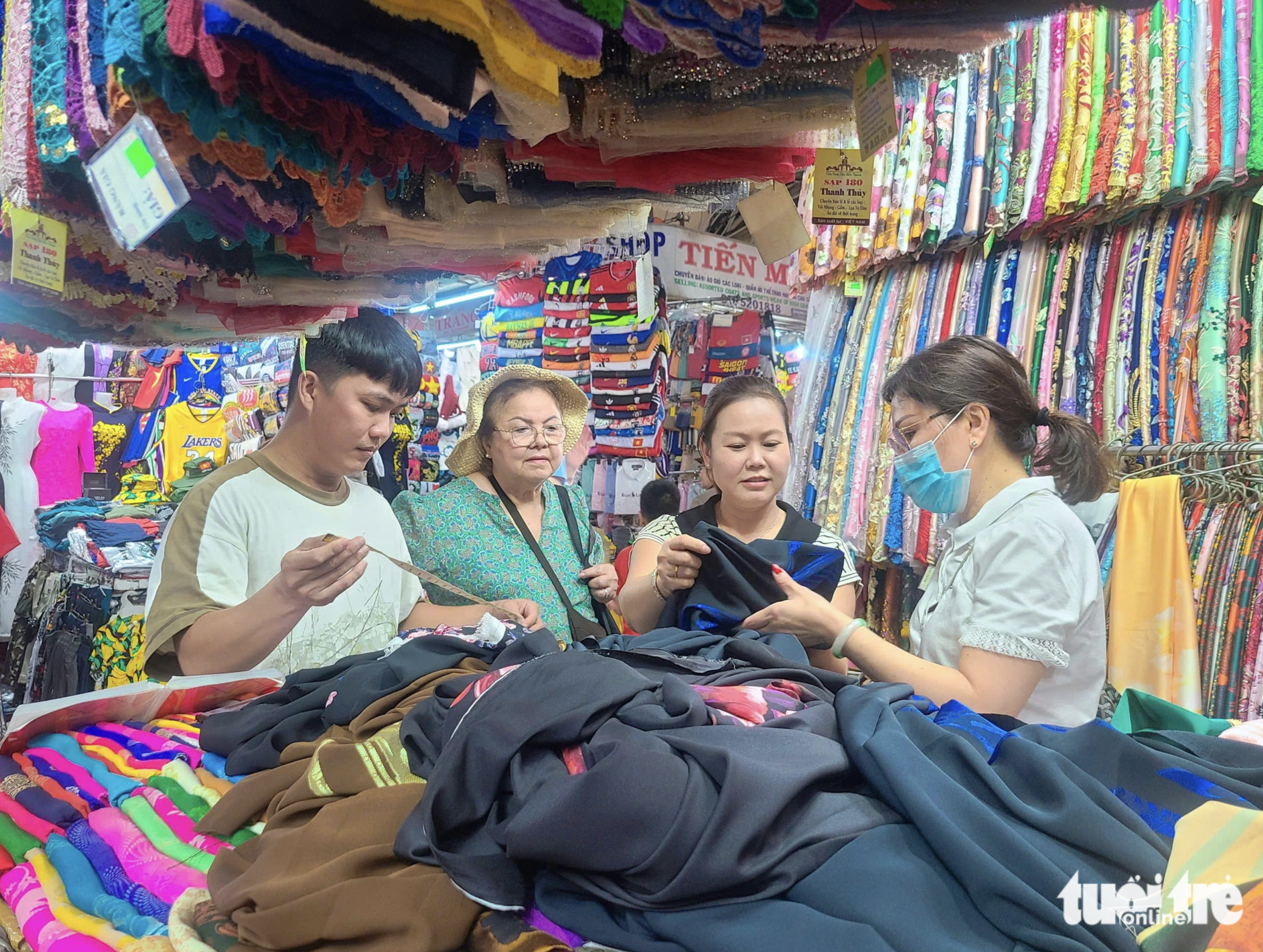 A stall of ao dai and fabric attracts international visitors. Photo: Nhat Xuan / Tuoi Tre