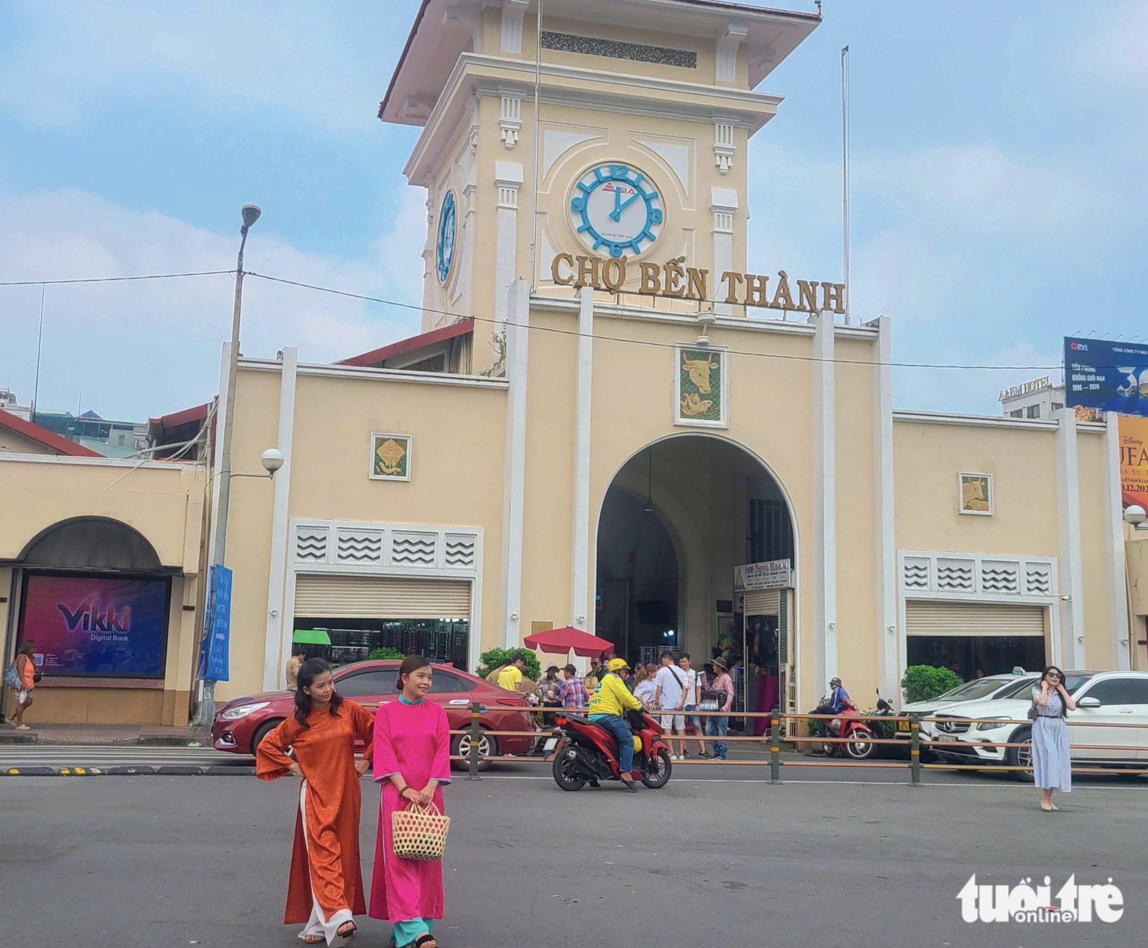 Girls in ao dai pose in front of the iconic Ben Thanh Market for photos. Photo: Nhat Xuan / Tuoi Tre