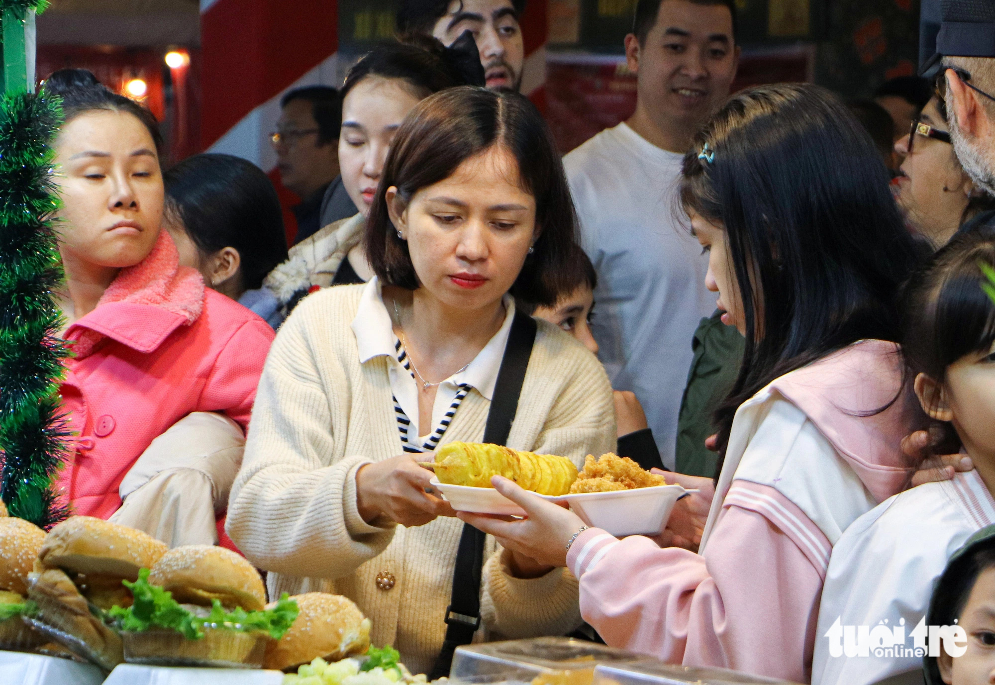 Visitors buy food at a Christmas bazaar on the bank of Dragon Bridge, Da Nang City, Central Vietnam. Photo: Thanh Nguyen / Tuoi Tre