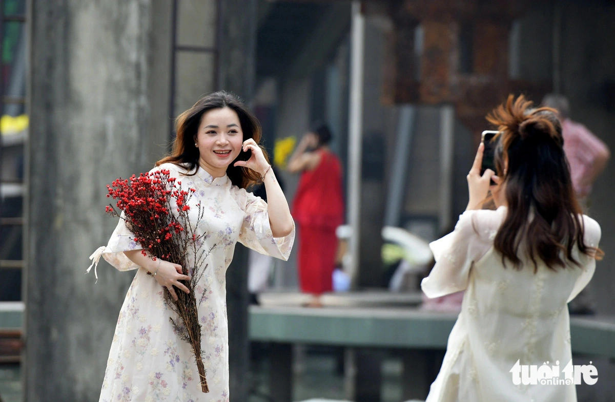 Young women in ‘ao dai’ at popular tourist destinations create a festive vibe in Ho Chi Minh City.