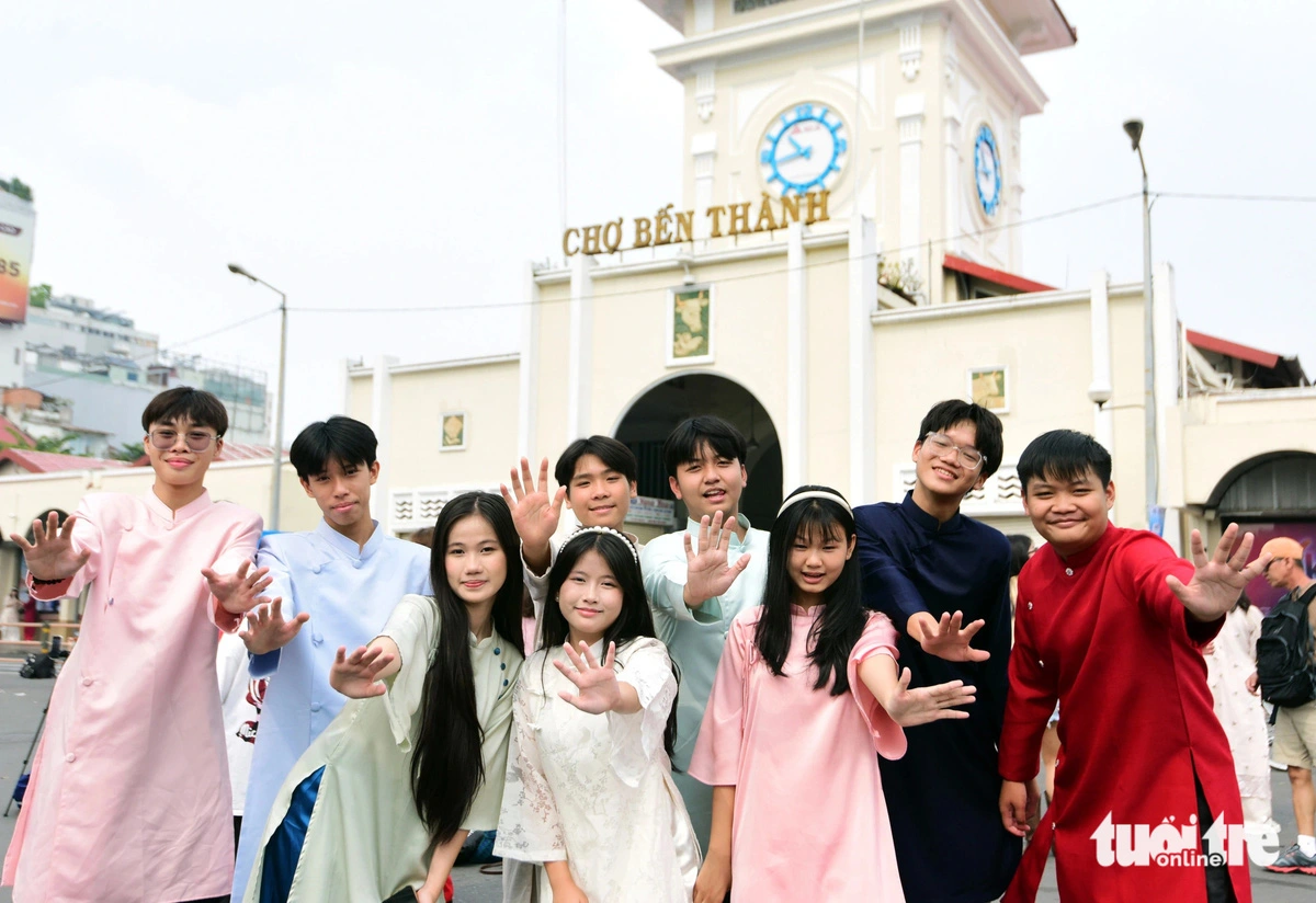 Young Vietnamese people donning ‘ao dai’ pose in front of Ben Thanh Market in Ho Chi Minh City.