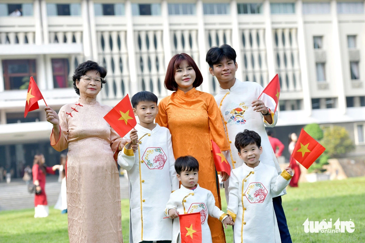 Loc (in an orange ‘ao dai’) from Binh Tan District, Ho Chi Minh City takes her mother and children to the downtown area for photos.