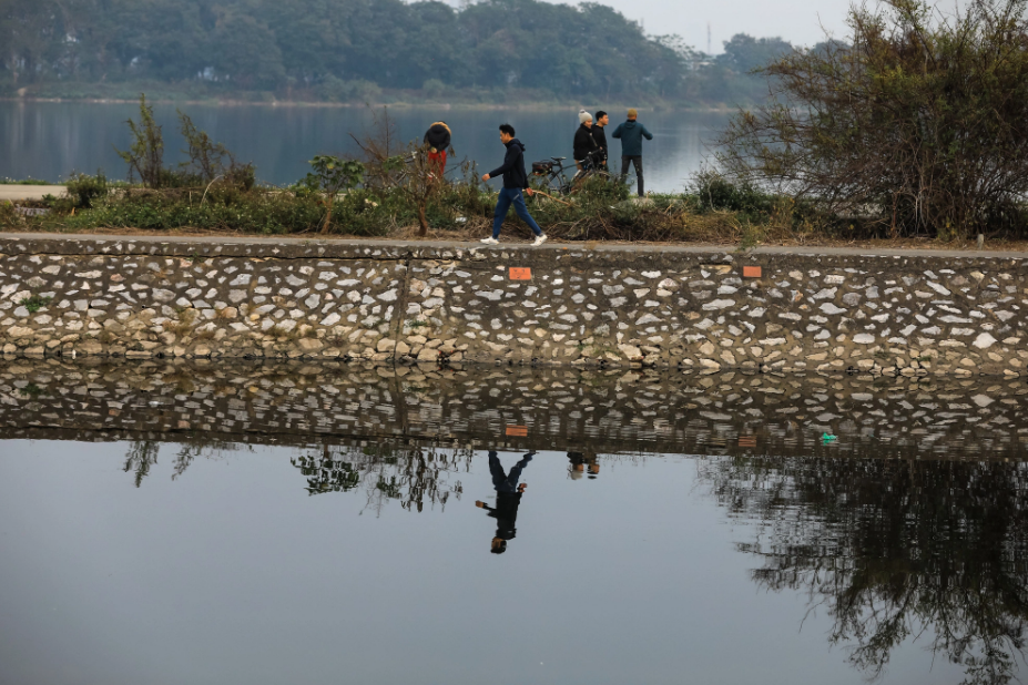 Residents exercise and jog along the polluted Set River in Hoang Mai District.