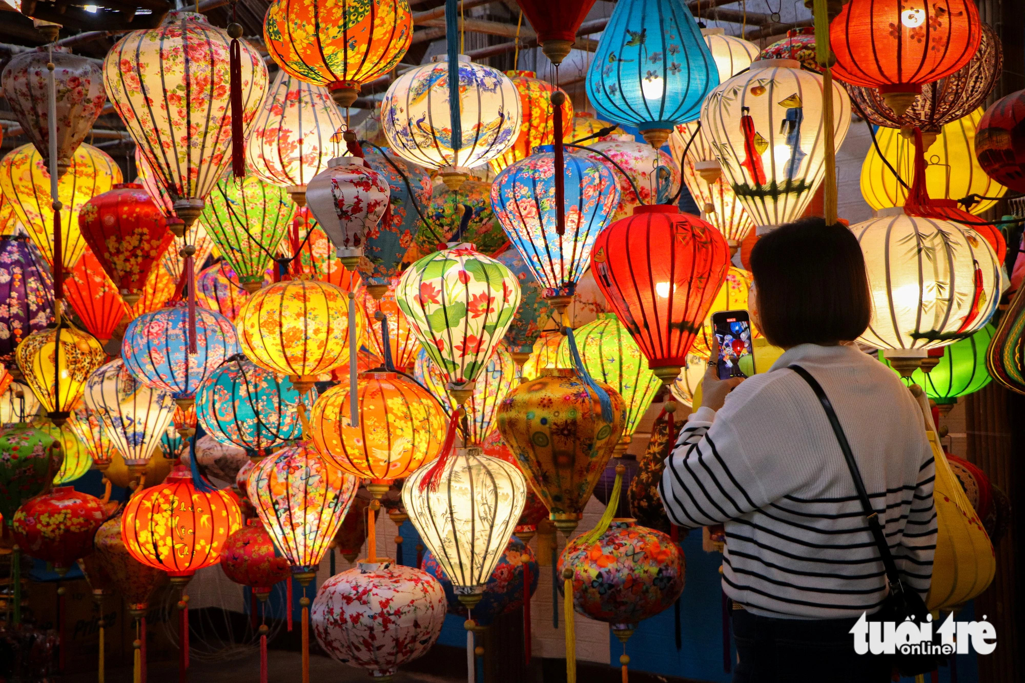 A tourist takes a photo of colorful lanterns in Hoi An City, Quang Nam Province, central Vietnam. Photo: Thanh Nguyen / Tuoi Tre