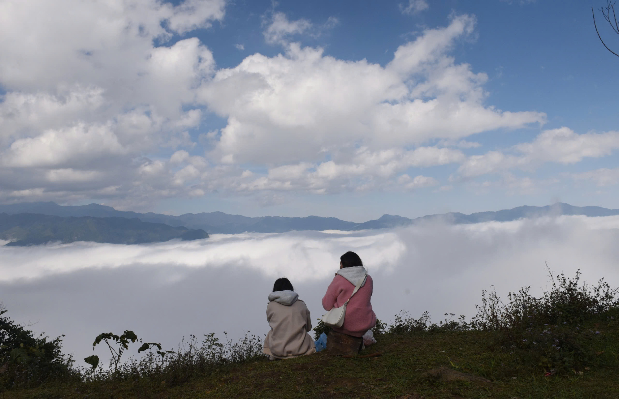 Women admire shifting clouds atop Khau Pha Pass in Mu Cang Chai District, Yen Bai Province, northern Vietnam.