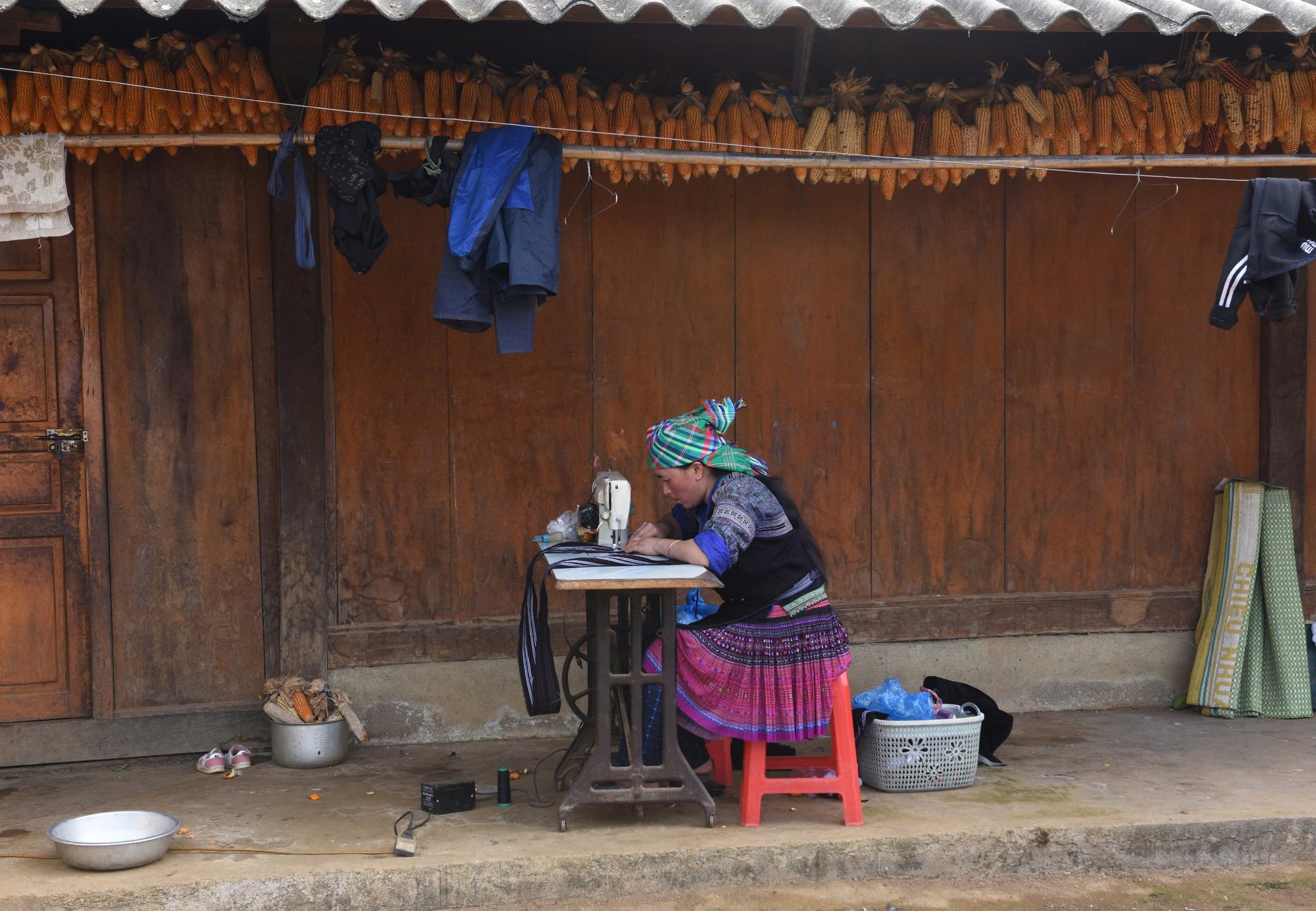 A Mong woman sews on the porch of her home in Mu Cang Chai Town, Mu Cang Chai District, Yen Bai Province, northern Vietnam.