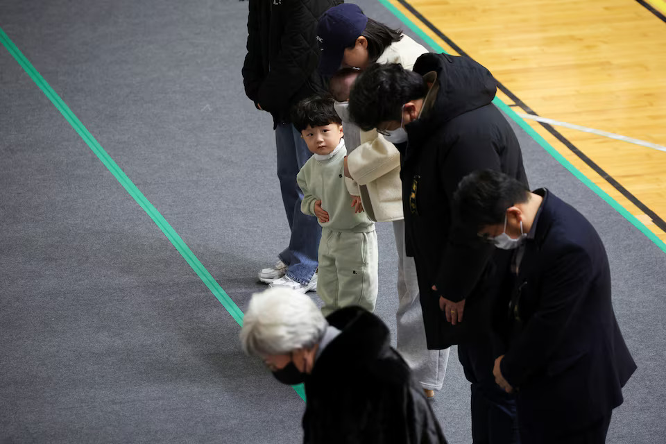 [10/11]A child looks on as mourners visit a memorial altar for the victims of the Jeju Air crash at Muan International Airport, at Muan Sports Park in Muan, South Korea, December 30, 2024. Photo: Reuters