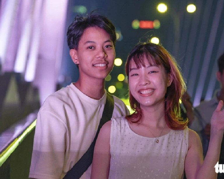 Thai travelers pose for a photo on the Ba Son Bridge in Ho Chi Minh City. Photo: Bui Nhi / Tuoi Tre