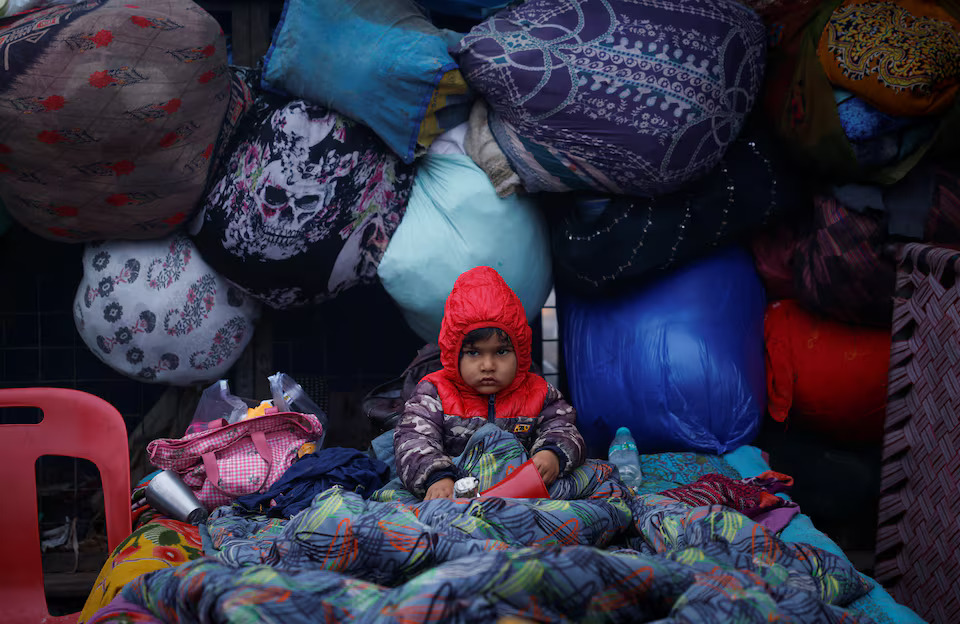 [4/5]A boy wrapped in a quilt sits on a cot at a parking area on a cold winter morning in the old quarters of Delhi, India, January 3, 2025. REUTERS/Adnan Abidi TPX IMAGES OF THE DAY Purchase Licensing Rights, opens new tab