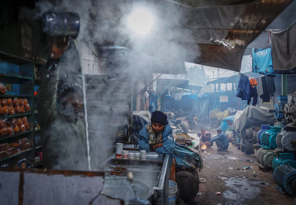 [5/5]People sit next to a fire at a market area on a cold winter morning in the old quarters of Delhi, India, January 3, 2025. Photo: Reuters