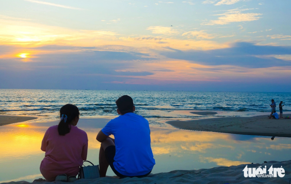 Tourists sit on Cua Lap Beach on Phu Quoc Island to watch the sunset. Photo: Chi Cong / Tuoi Tre