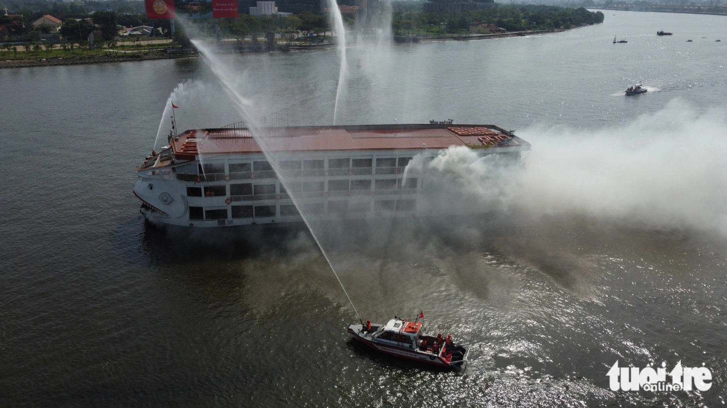 Speedboats are mobilized to the scene where the yacht is on fire to spray water onto it. Photo: Minh Hoa / Tuoi Tre