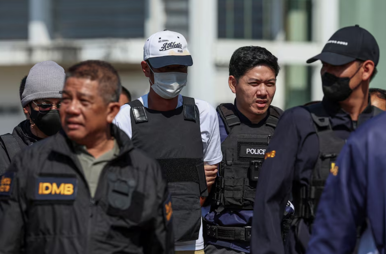 Ekalak Paenoi, a suspect in the assassination of a former politician with now-dissolved Cambodia National Rescue Party (CNRP) Lim Kimya, 74, is escorted by police officers as he arrives in Thailand following handing over from Cambodia to Thai authorities, in Bangkok, Thailand, January 11, 2025. Photo: Reuters