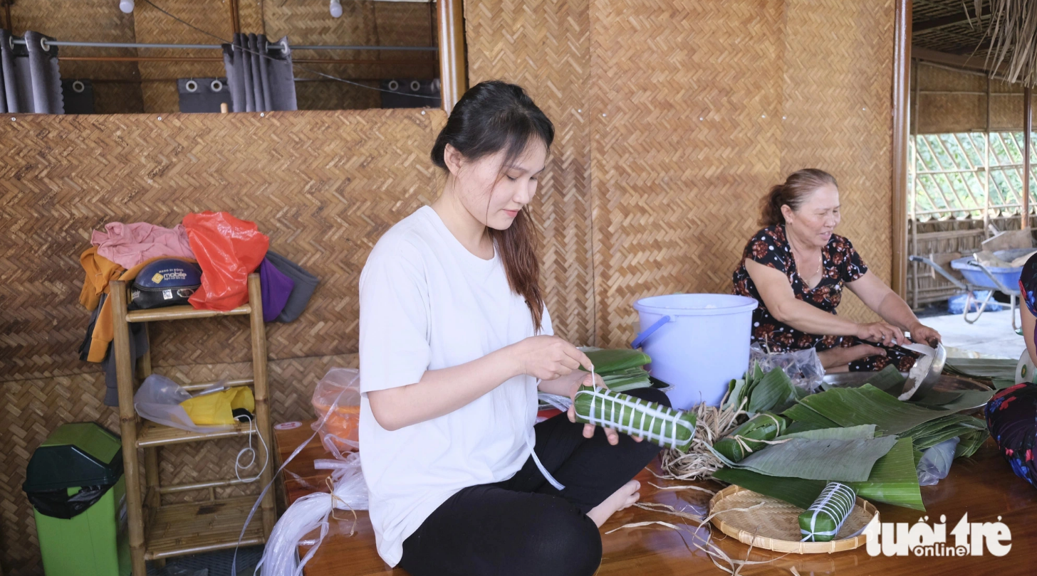 Tourists can join the host in wrapping banh tet at a tourist area in Dong Thap Province. Photo: Dang Tuyet / Tuoi Tre