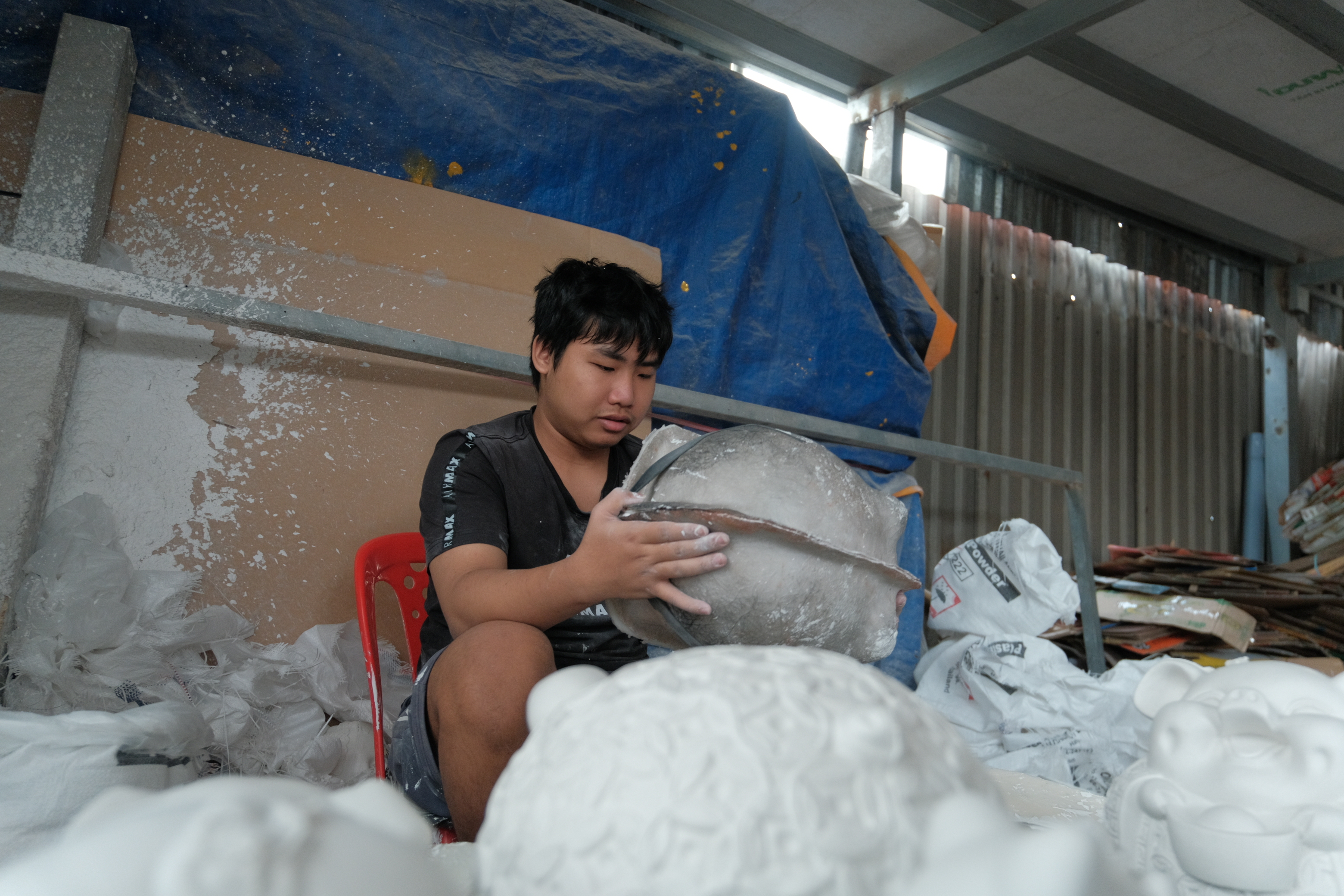 A worker pours plaster into molds to shape piggy banks. This material allows faster production and will set in 10–15 minutes. Photo: Ngoc Phuong / Tuoi Tre News