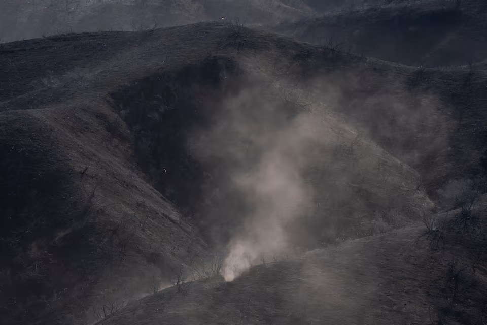 The wind blows ash through burned hills in the Tarzana area during the Palisades Fire in Los Angeles, California, U.S. January 13, 2025. Photo: Reuters