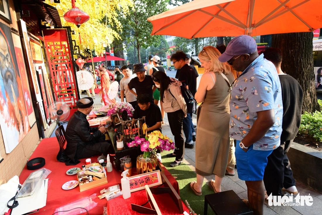 A calligrapher stall attracts many local and foreign visitors at the 2025 Vietnamese Tet Festival at the Youth Culture House in Ho Chi Minh City, January 13, 2024.