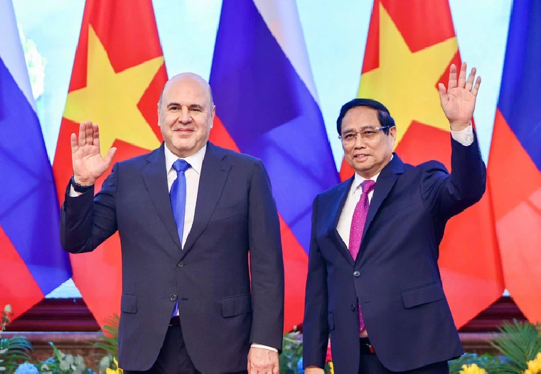 Vietnamese Prime Minister Pham Minh Chinh (R) and his Russian counterpart Mikhail Vladimirovich Mishustin waves their hands at local journalists in Hanoi, January 14, 2025. Photo: Nguyen Khanh / Tuoi Tre